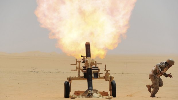 A Saudi soldier fires a mortar towards Houthi movement position, at the Saudi border with Yemen on April 21.