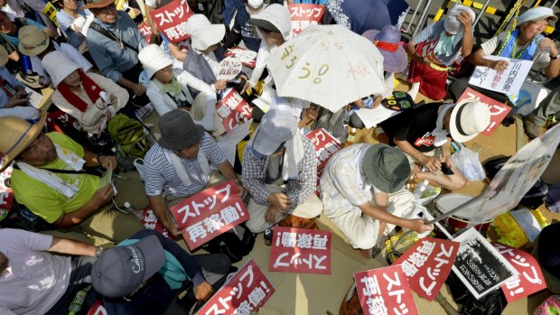 Protesters stage a rally near the gate of the Sendai Nuclear Power Station.