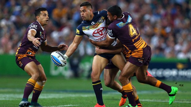 Offload: Antonio Winterstein passes the ball in a tackle by Justin Hodges.