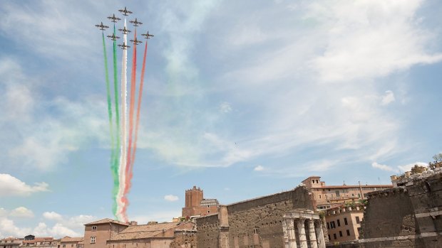 The Frecce Tricolore air squadron flies over the Via dei Fori Imperiali during the military parade to mark the founding of the Italian Republic and the 150th anniversary of Italian unification after the death of Benito Mussolini. 