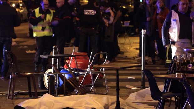 A victim is pictured on the pavement outside a Paris restaurant on Friday.