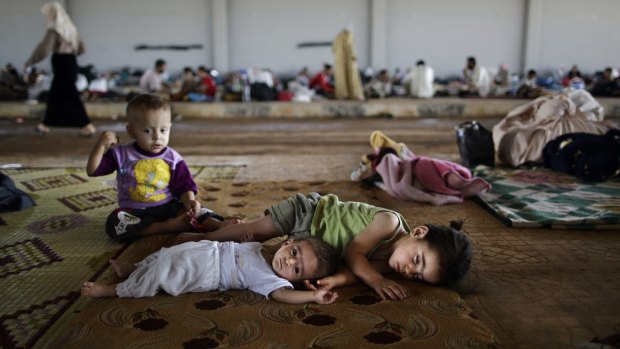 Syrian children lie on the ground at the Bab Al-Salameh border crossing.