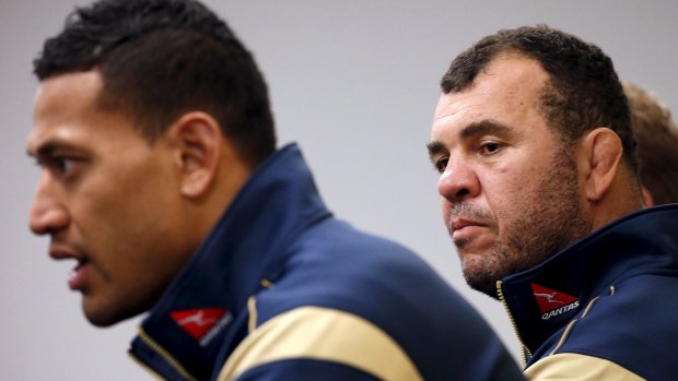 Coach Michael Cheika listens to Israel Folau speak at a media conference on Tuesday.