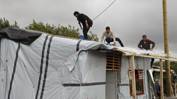 Migrants build a temporary shelter at the migrant camp known as the New Jungle in Calais.