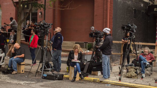 Media wait outside of a building in New York where Kim Kardashian West and husband Kanye West are staying on Monday.
