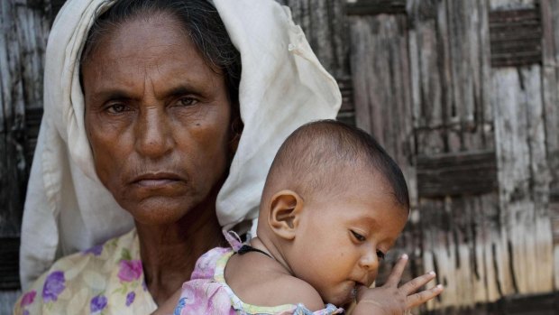 An ethnic Rohingya Muslim woman holding a baby at a camp set up outside the city of Sittwe in Myanmar's Rakhine state. 