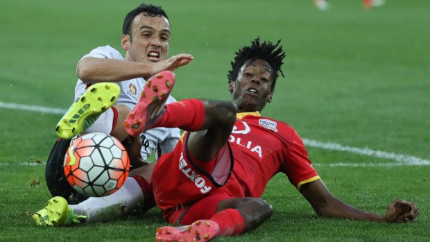 Mark Bridge, of the Wanderers, challenges Bruce Kamau, of Adelaide United, during their  A-League grand final match.