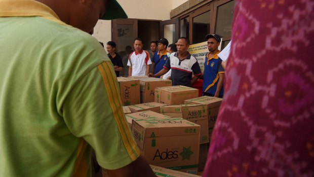 Members of the Taskforce unload water for evacuees at Tanah Ampo Post Command in Bali