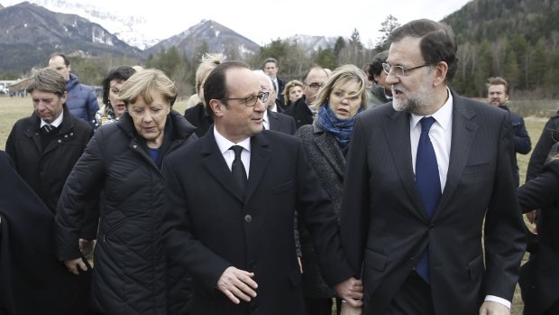 France's President Francois Hollande (centre), Spain's Prime Minister Mariano Rajoy (right) and German Chancellor Angela Merkel walk on a field near the crash site of Germanwings Airbus A320 near Seyne-les-Alpes.