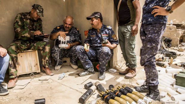 Iraqi federal police use a commercially-made drone, connected to one of their cellphones, to observe the accuracy of their mortar fire, in the al-Risala district of Fallujah.