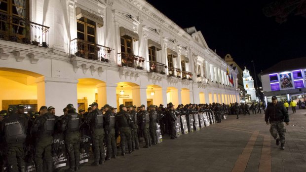 Police and military officers stand guard outside around Carondelet Palace in Quito, Ecuador last week.