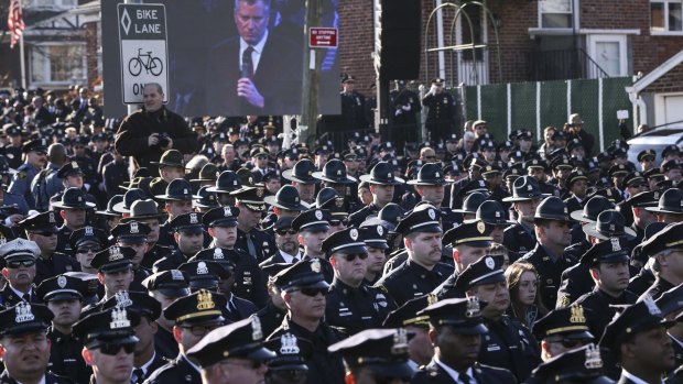 Cold shoulder: Police officers turn their backs on a live video monitor showing New York City Mayor Bill de Blasio as he speaks at the funeral of slain New York Police Department officer Rafael Ramos.