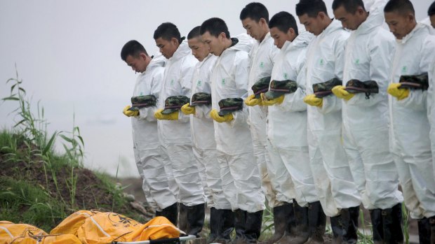 Rescue workers pay respects to victims after a cruise ship sank at the Jianli section of the Yangtze River, in China on Monday night.