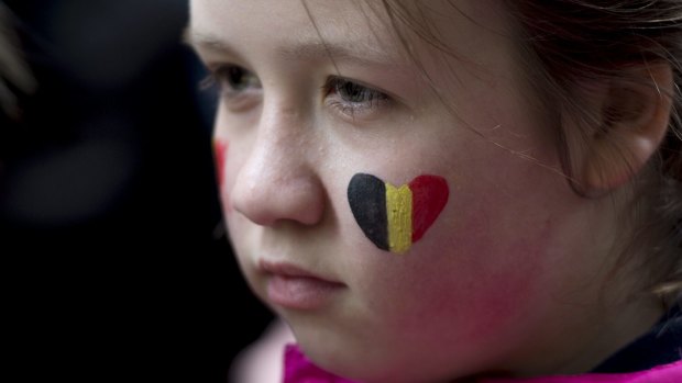 A child looks on during a vigil for the victims of the Brussels attacks at the Belgium Consulate in Montreal, Canada, on Wednesday.