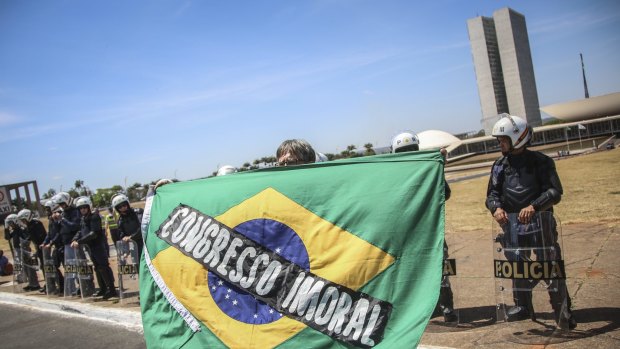 A demonstrator holds a Brazilian flag that reads "Immoral Congress" during a protest against government corruption in front of the Congress building on Brazillian independence day last week.