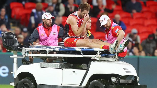 Gold Coast's Michael Barlow is taken from the field with a leg injury.