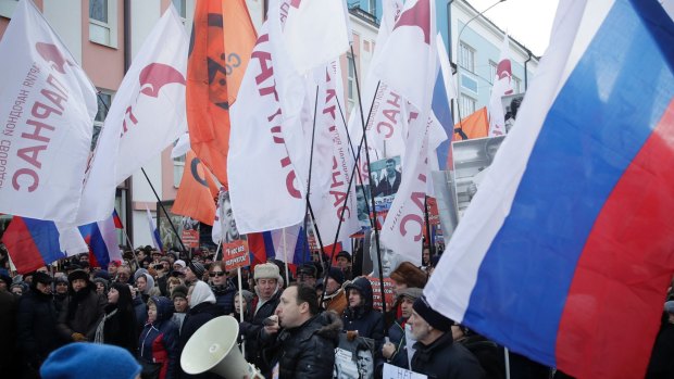 People, with flags of different opposition movements, march in memory of opposition leader Boris Nemtsov, in Moscow, on Sunday.