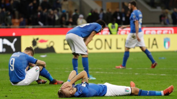 Agony: Italian players react to their elimination at the end of the play-off against Sweden.