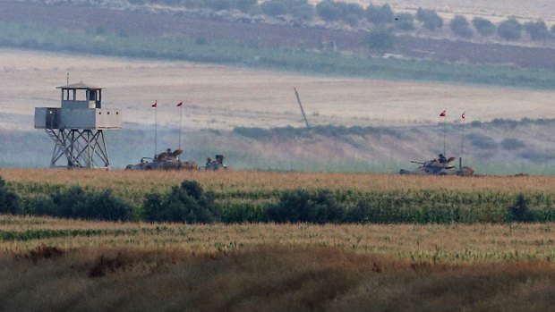 Clashing with IS ... Turkish army tanks hold positions near the border with Syria, in the outskirts of the village of Elbeyi, east of the town of Kilis, in southeastern Turkey.