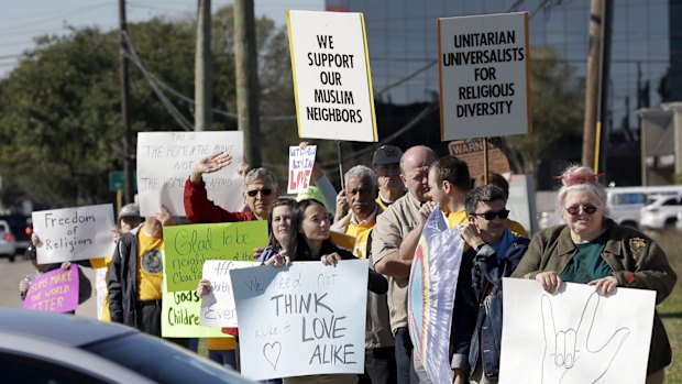 People hold signs during a rally to show support for Muslim members of the community near the Clear Lake Islamic Centre in Webster, Texas, on Friday.