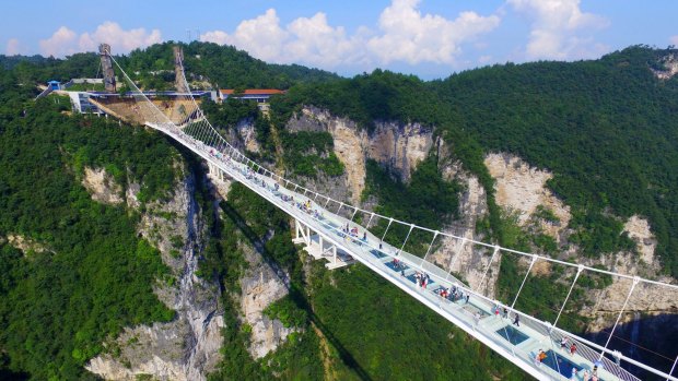 The bridge, which opened to the public on a trial basis on Saturday, spans 430 meters and rises about 300 meters above a valley.