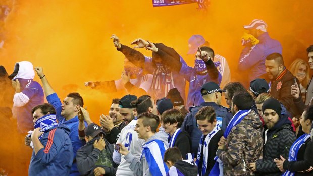 A flare is set off among Greek supporters in the crowd.