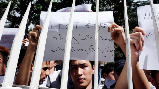 Dozens of asylum seekers hold posters during protest in front of the UNHCR office in Jakarta on Monday.