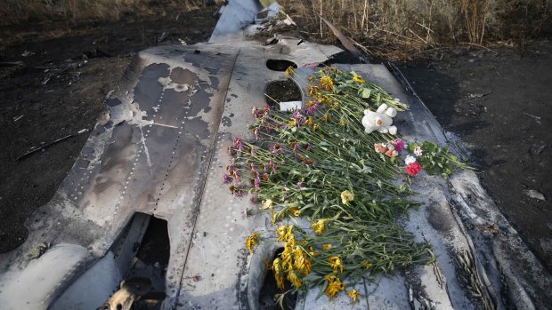 Flowers and mementos lie on wreckage at the crash site of Malaysia Airlines Flight MH17, near the settlement of Grabovo in the Donetsk region of the Ukraine on July 19, 2014. 