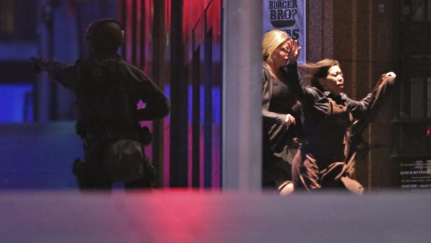 Hostages run to safety from the Lindt cafe.