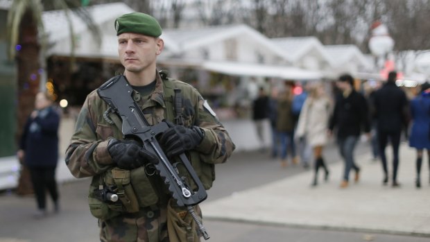 A French soldier patrols the Christmas market along Champs Elysees in Paris.