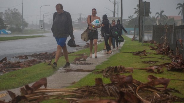 Backpackers from England, Germany and Finland leave the Bowen cyclone evacuation centre in the aftermath of Cyclone Debbie.