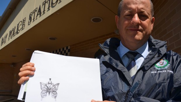 Crime manager Detective Inspector Kevin McNeil with a copy of the butterfly pendant.