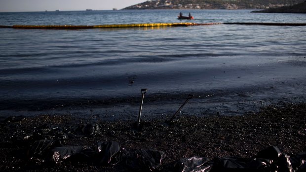 A small boat passes in front of an affected beach on the island of Salamina, near Athens, on Friday.
