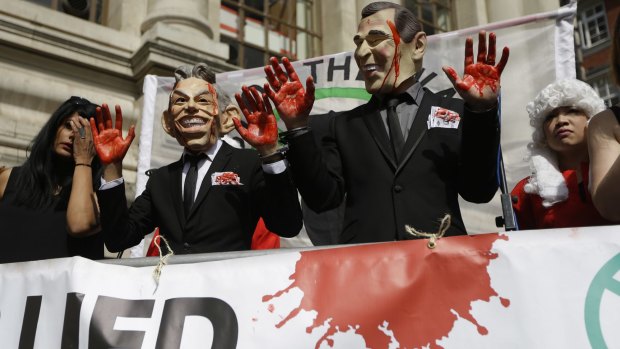 Protesters wearing Tony Blair and George W. Bush masks protest in London shortly before the publication of the Chilcot report.