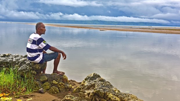 Sailosi Ramatu looks over the sea at his old village Vunidogoloa in Fiji. Each time the ocean surged through their coastal Fijian village, residents would use rafts to move from house to house. 