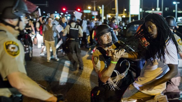 St Louis County police officers hold an anti-police demonstrator in Ferguson, Missouri on Monday.