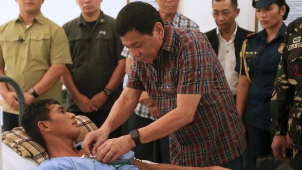 Philippine President Rodrigo Duterte pins a medal on a soldier wounded in the August 2016 gunbattle with Abu Sayyaf militants.