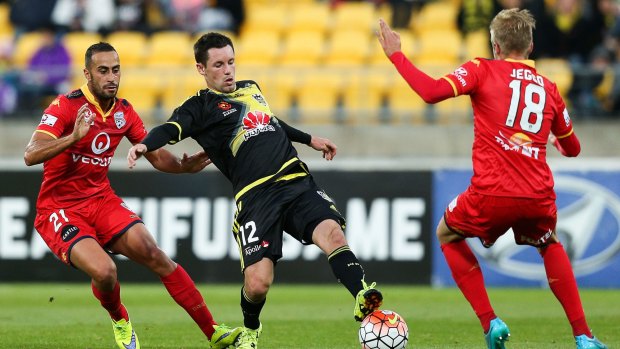 Blake Powell of the Phoenix finds himself sandwiched between Tarek Elrich (left) and James Jeggo of Adelaide United.