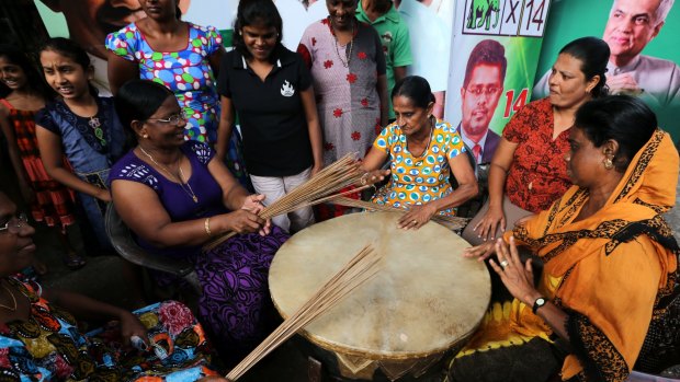 Supporters of UNP perform with a traditional drum as they celebrate their party victory.