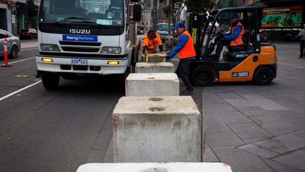Construction workers installing temporary concrete bollards around Federation Square on June 10, 2017.