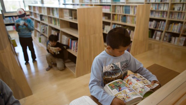 Ryuya Kusano reads a comic book in the library at Naraha Elementary and Junior High School.