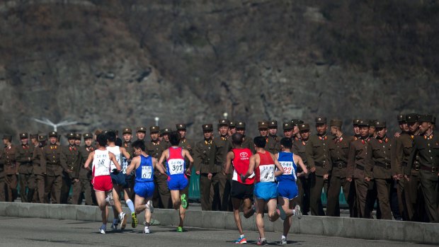 Marathon runners pass by a long row of North Korean soldiers during the Pyongyang marathon in 2013. 