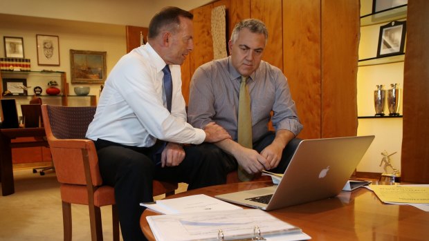 Prime Minister Tony Abbott poses with the Treasurer Joe Hockey as they look through the 2015 budget on Tuesday.