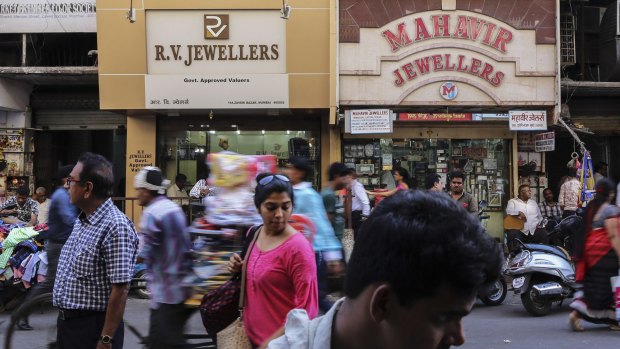 Pedestrians walk past jewellery and bullion stores in the Zaveri Bazaar in Mumbai, India.