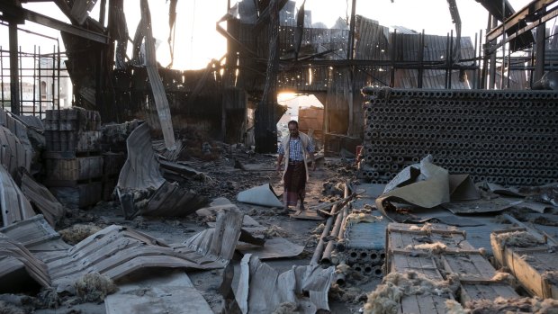 A man walks through the remains of a factory that was bombed twice in September outside of Yemen's capital Sanaa.