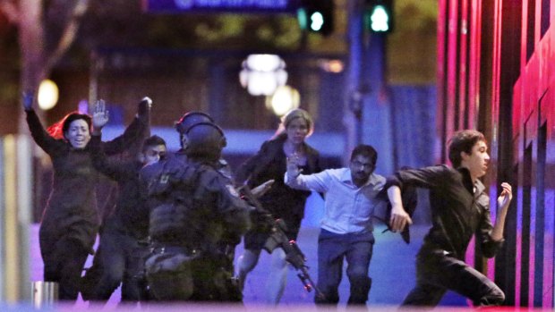 Five hostages run from the Lindt Cafe  building towards Special Operations Police in Martin Place on December 16 last year.