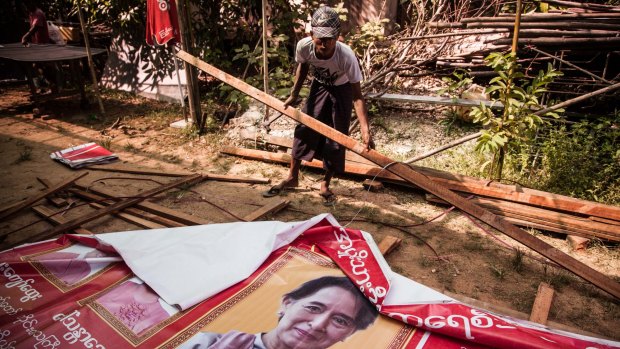 Volunteers take down posters of Aung San Suu Kyi at the National League for Democracy Party head office on Friday. 