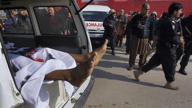 An ambulance transports the body of a victim while Pakistani troops gather at the main gate of Bacha Khan University in Charsadda town.