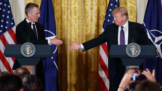 President Donald Trump reaches to shake hands with NATO Secretary General Jens Stoltenberg during a news conference in the East Room of the White House in Washington.