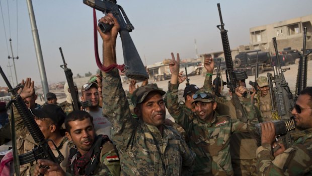 Iraqi soldiers fighting to retake Mosul celebrate on the outskirts of Qayyarah, Iraq, on Wednesday.